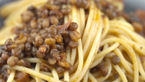 lentil pasta, vegan pasta, vegan spaghetti dish, close up of spinning bowl of vegetarian pasta. mushroom dish. italian lentil meal.