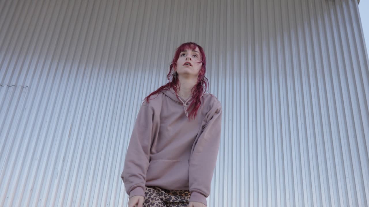 Young urban dancer performing in front of metal wall