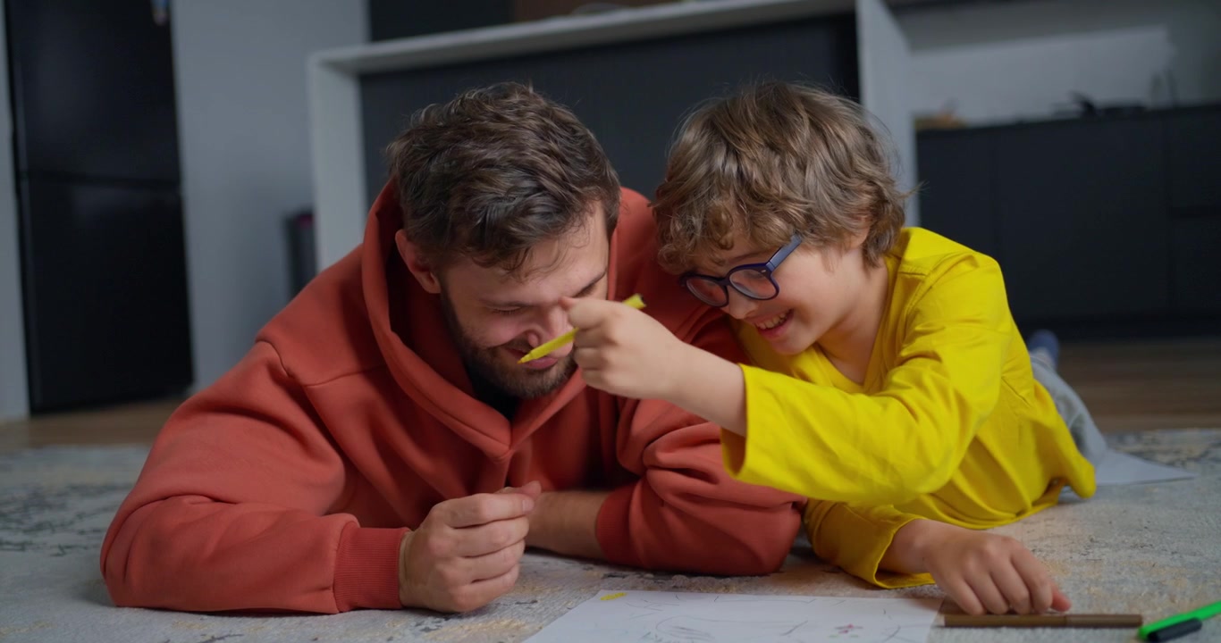 Happy Father and Son Coloring Together on the Floor