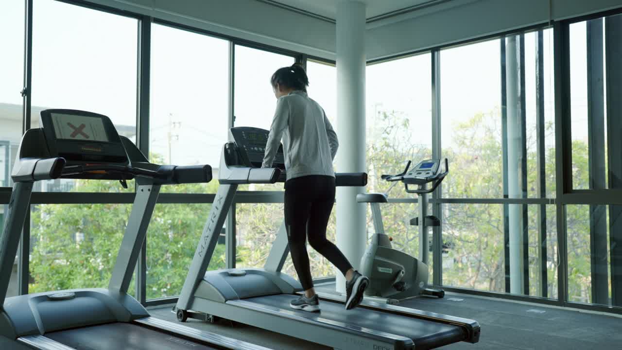 Woman pressing to start running on a treadmill