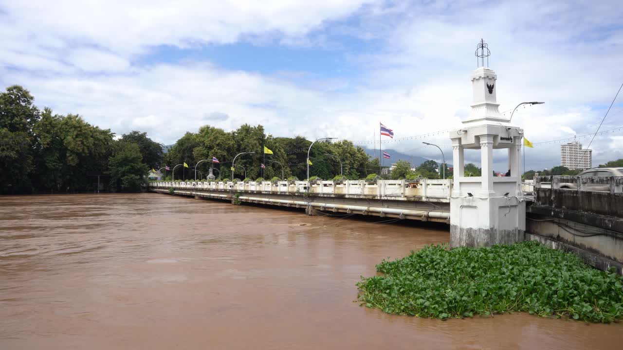 치앙마이 (thailand) 의 나와라트 다리의 광범위한  (wide shot of nawarat bridge in chiang mai) - 마이 핑 강이 홍수를 일으키고 다리 수준에 도달합니다 - 전기 케이블이 침몰 된 빠르게 흐르는 갈색 물, 다리 홍수 태국 발, 2024 년 9 월