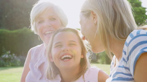 three female generations of a family laughing in the garden