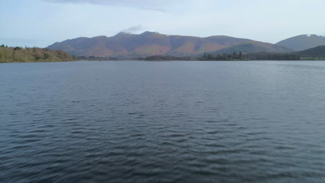 low aerial drone shot over derwentwater keswick revealing skiddaw mountain in background north lake district cumbria united kingdom