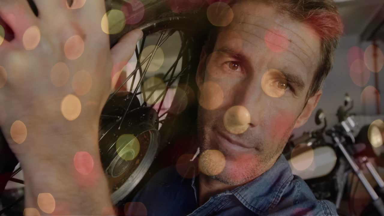 animación de luces parpadeantes sobre un mecánico caucásico que sostiene la rueda de una motocicleta