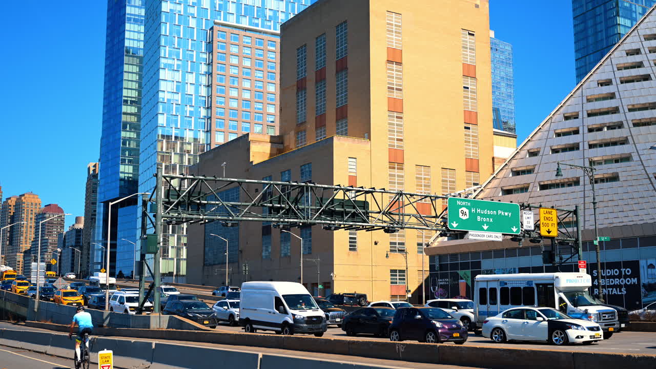 New York, USA, 26 marzo 2026: Traffico intenso sulla West Side Highway a New York City. Fila di auto e veicoli commerciali su una superstrada urbana con moderni grattacieli e segnali stradali a Manhattan.