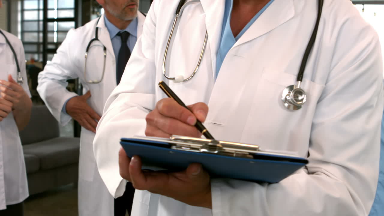 Vista a mezzo busto di un medico che scrive su un blocco appunti