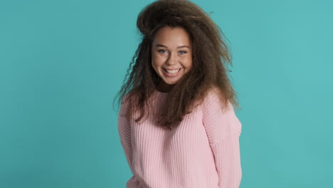 caucasian curly haired woman waving to the camera.