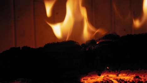 llama ardiente en la chimenea en troncos de madera