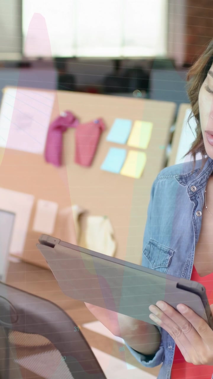 Vertical video: Woman holding tablet, reviewing finance data, causing charts sweeping across office