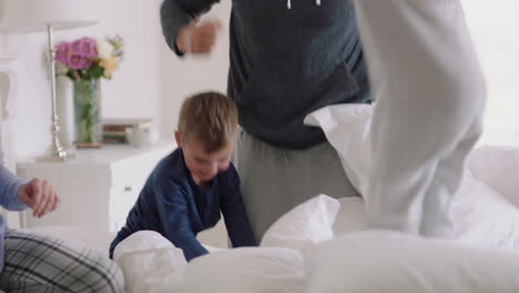 happy-family-with-children-jumping-on-bed-playing-with-mother-and-father-having-fun-on-weekend-morning-excited-little-kids-enjoying-game-with-parents-at-home-4k-footage