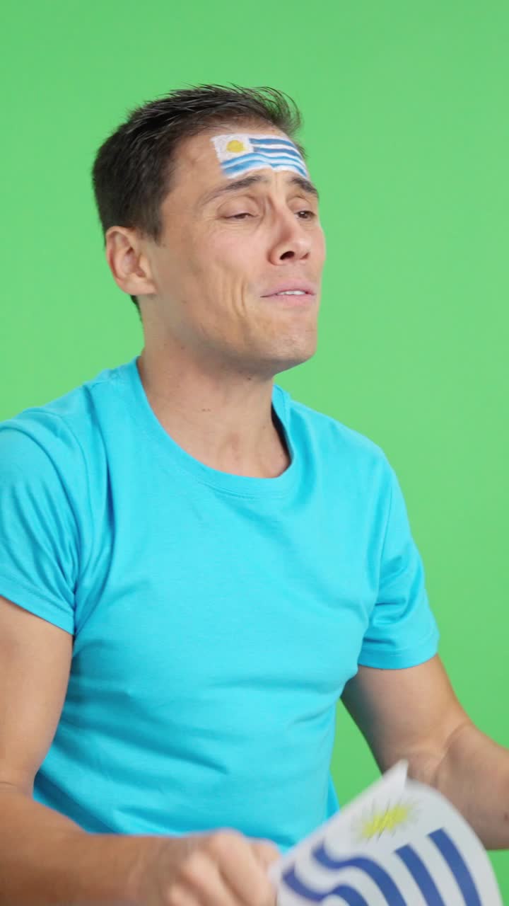 Nervous man cheering for Uruguay during a match looking away