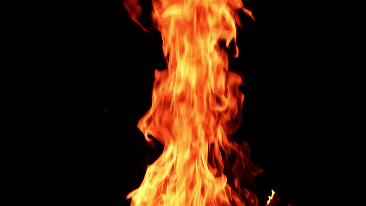 Huge bonfire rising up in the darkness. Dangerous red flame going up at night.