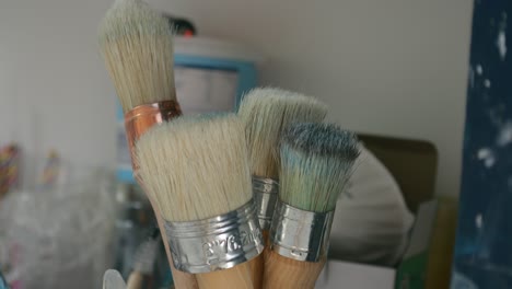 artistas pinceles en un frasco de vidrio, en un estudio en casa ocupado