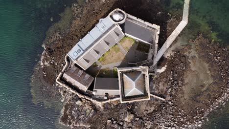 Low-altitude,-rotating,-birds-eye-view-drone-shot-of-Kisimul-castle-in-Castlebay-on-the-Isle-of-Barra-in-the-Outer-Hebrides-of-Scotland