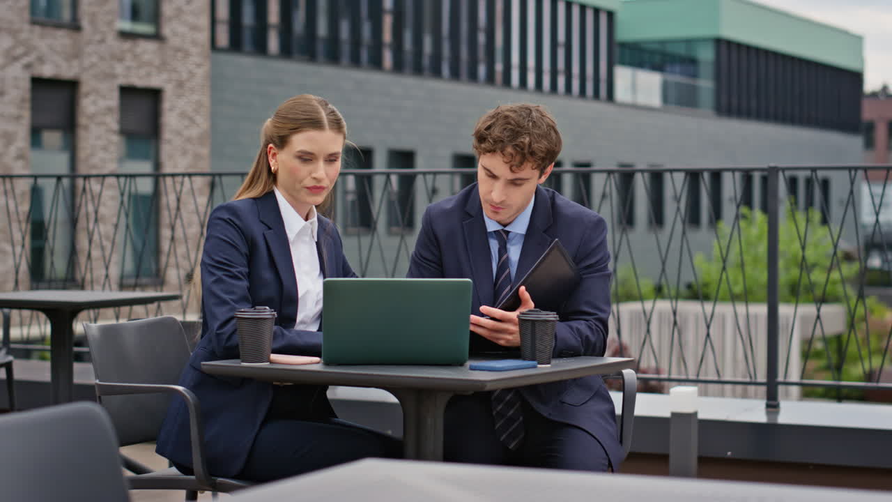 Business partners planning project on outdoors office terrace. Serious coworkers