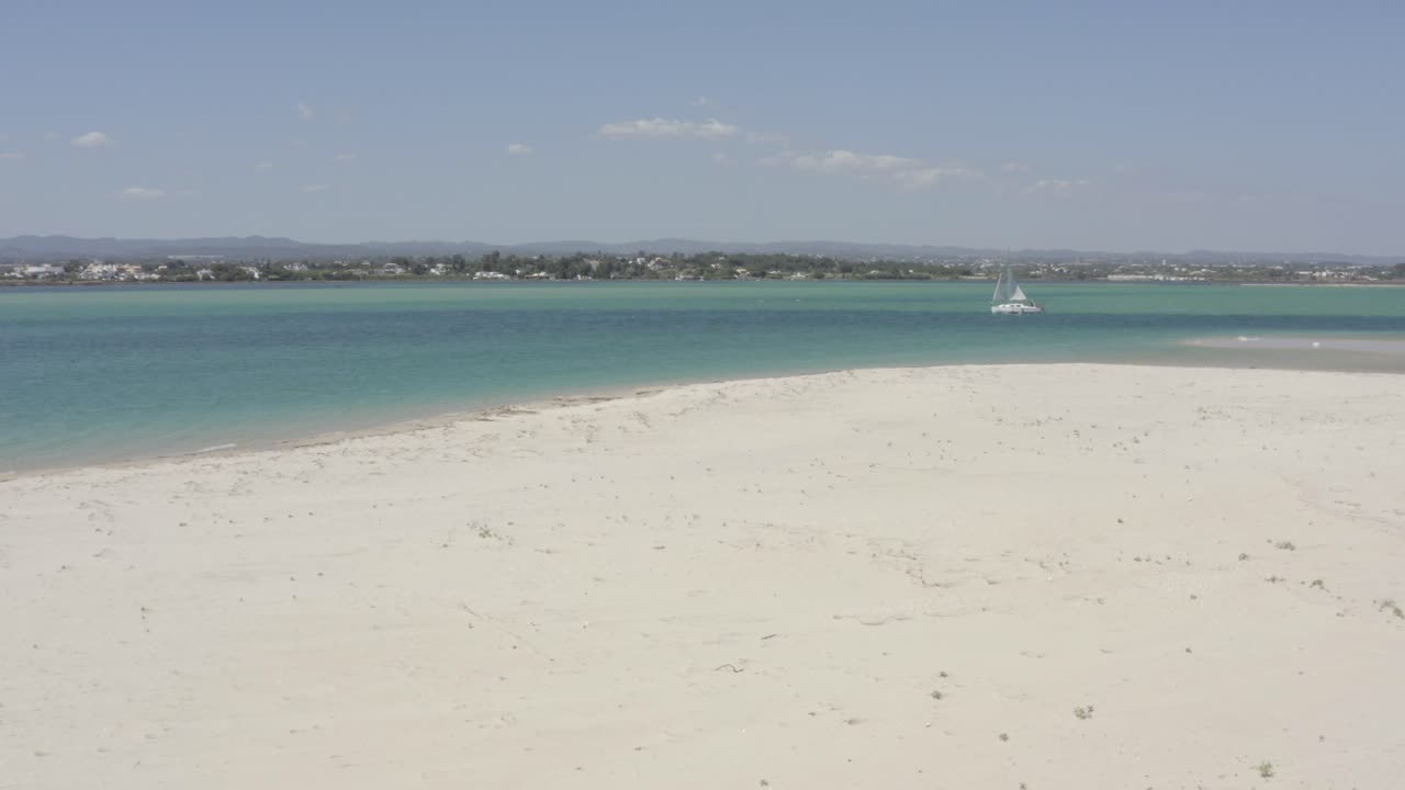 청록색 이국적인 바다를 항해하는 놀라운 흰색 범선을 향해 놀라운 백사장 푸제타 해변 위를 날고 있는 드론 항공