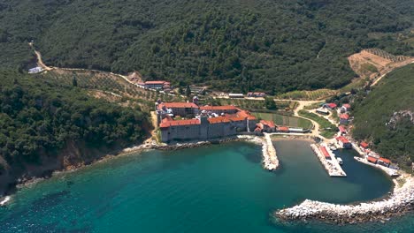 an aerial view of a coastal medieval monastery in the holy mountain in greece