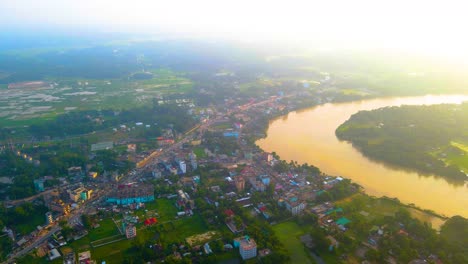 aerial suburban village by surma river in bangladesh, early morning mist