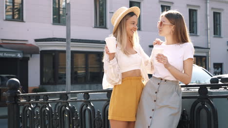 two friends enjoying coffee on a city street