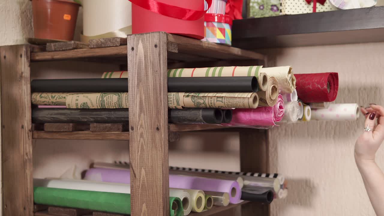 공예 가게 에서 선물 포장 종이 롤 을 가진 나무 선반 단위