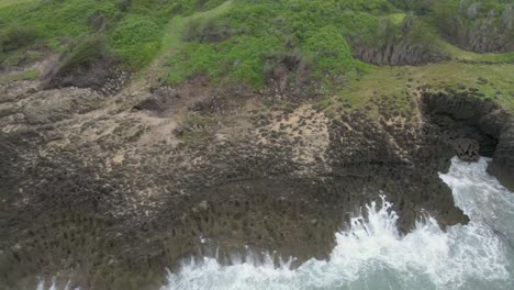 Vista-Aérea-Del-Agua-De-Mar-Golpeando-La-Roca-En-La-Costa