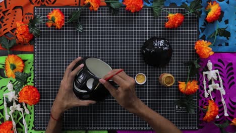 POV-of-man-painting-black-ceramic-lantern-for-Halloween-decoration