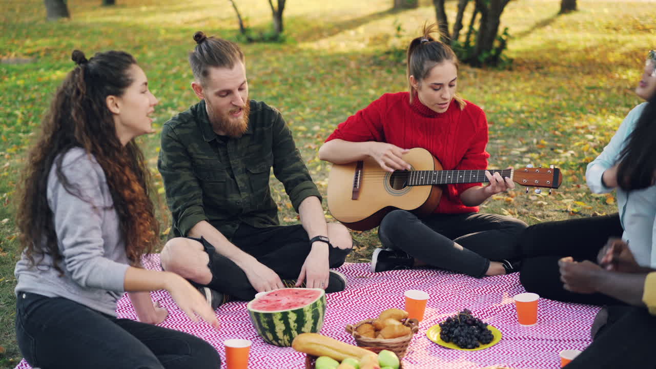 Friends Enjoying a Picnic and Music in the Park
