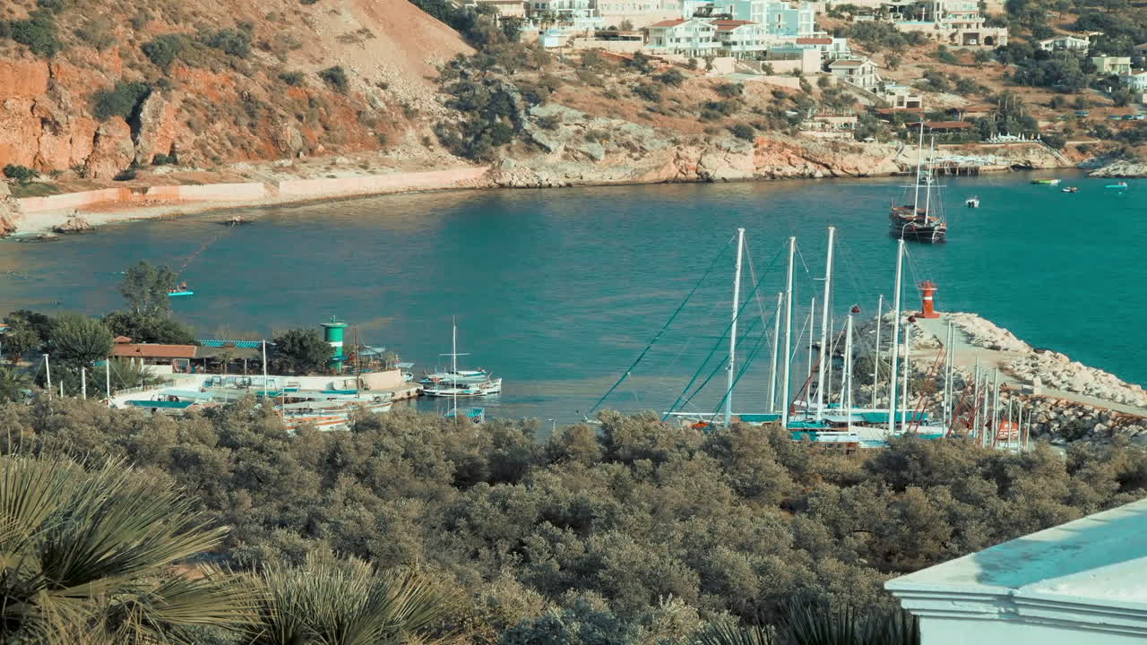 lapso de tiempo del ajetreado puerto de kalkan en turquía, filmado desde la ladera de la montaña mientras los barcos llegan y parten llevando a los turistas en viajes en barco