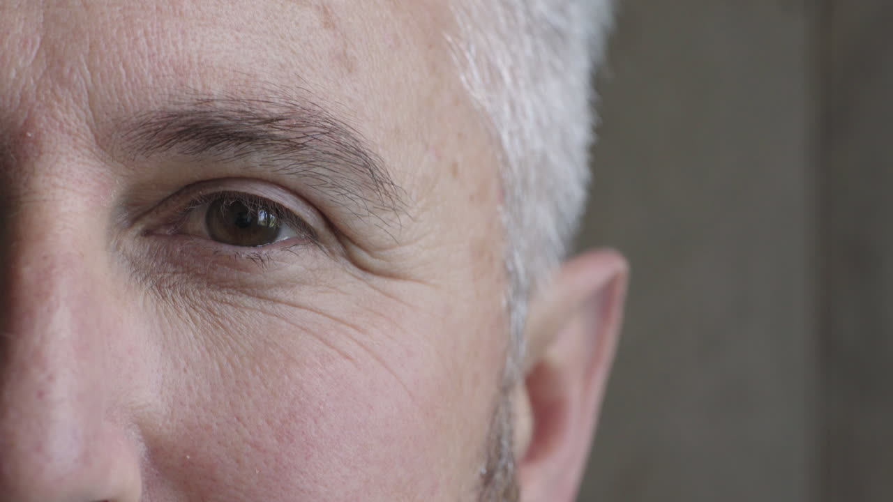 aus der nähe reife mann auge schaut in die kamera blinkendes halbes gesicht