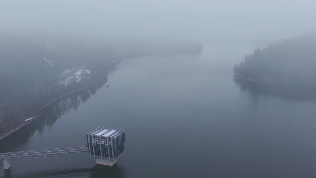 Dam from an aerial view in winter. Letovice on a cold, foggy morning. Water reservoir
