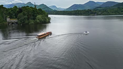 drone aerial footage of a river boat on derwentwater, keswick, a calm lake with river boats and a stormy sky