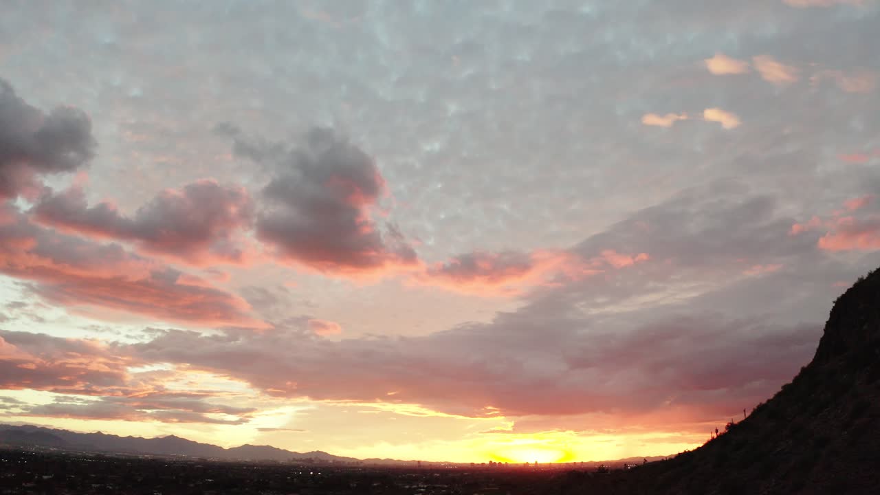 Panning shot from Camelback Mountain's peak to reveal a beautiful Arizona sunset