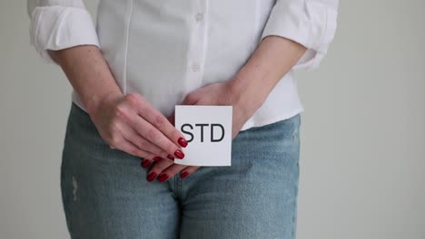 person holding std card covering groin area
