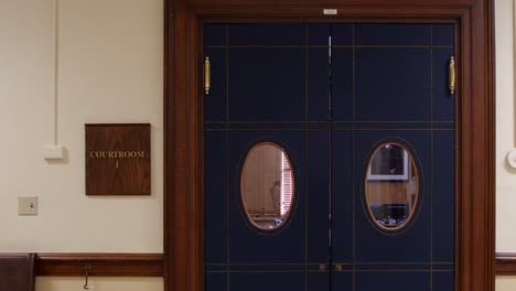 4k courtroom trial doors leading into court room with sign on wall in courthouse lobby medium shot for b roll