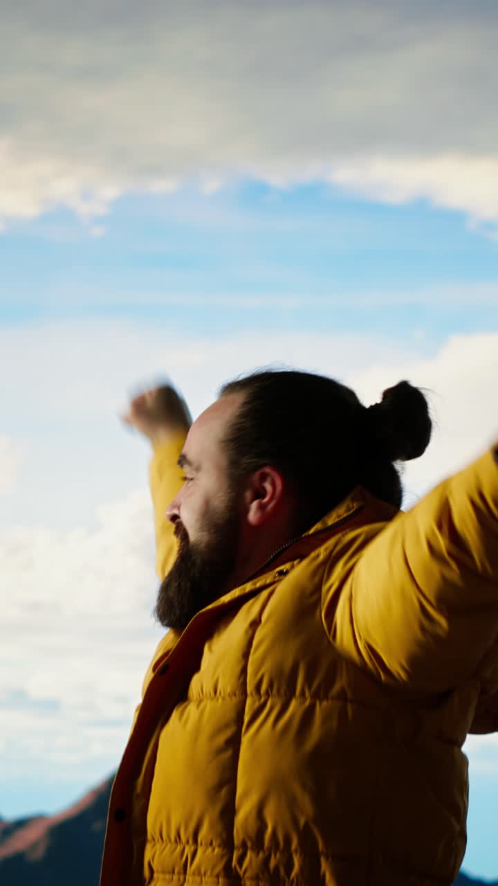 Joyful Man with Beard Raising Arms in Celebration Outdoors