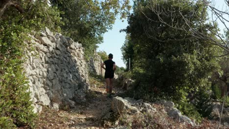 hombre sano y en forma corriendo por un estrecho sendero de montaña con perro