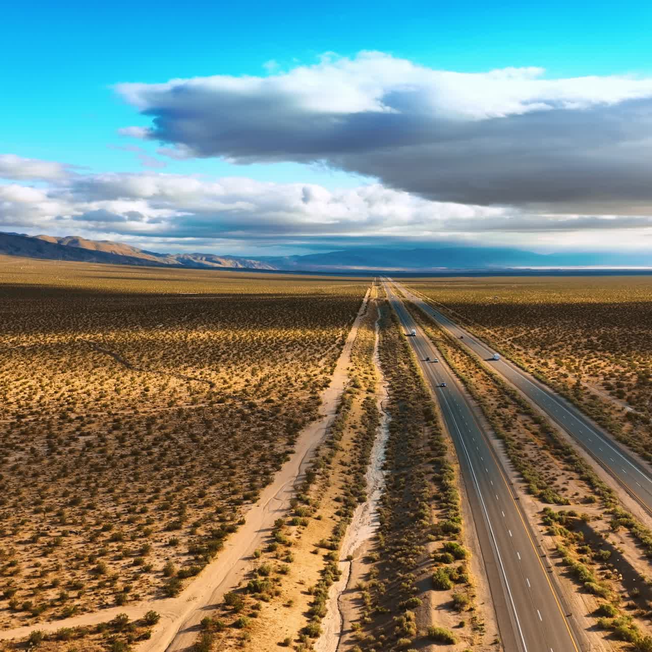 Flying above the highways crossing the deserted land. Numerous little bushes covering the dry landscape. Aerial view