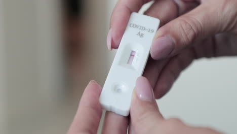 girl holding rapid diagnostic test kit showing negative line result for covid-19