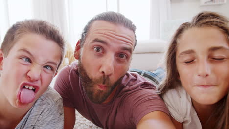 point of view shot of father and children posing for selfie