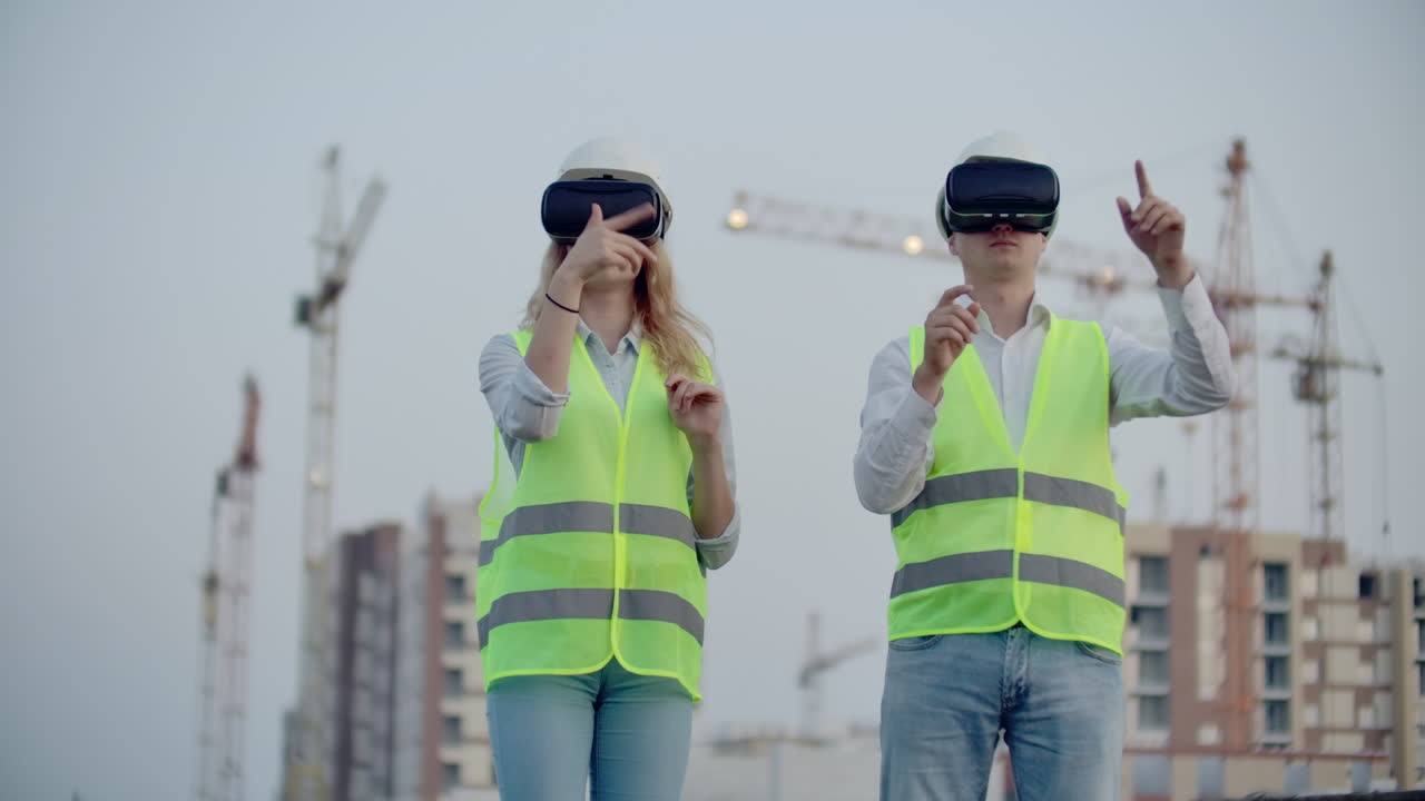 dos personas hombre y mujer con gafas de realidad virtual en el fondo de los edificios en construcción con grúas. gerente y asistente en el diseño con las manos imitando la interfaz de la aplicación