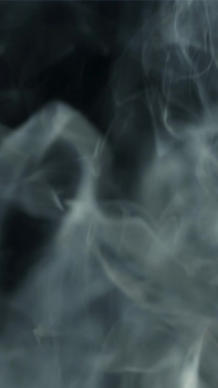 Fumo bianco astratto che turbina e sale su uno sfondo scuro
