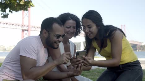 Jóvenes-Amigos-Felices-Usando-Un-Teléfono-Inteligente