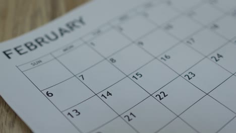 mano lanzando ladrillos en forma de corazón rojo en el calendario 14 de febrero fecha día de san valentín
