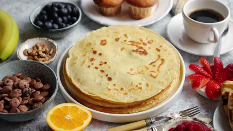 breakfast table setting with fresh fruits  pancakes  coffee  croissants