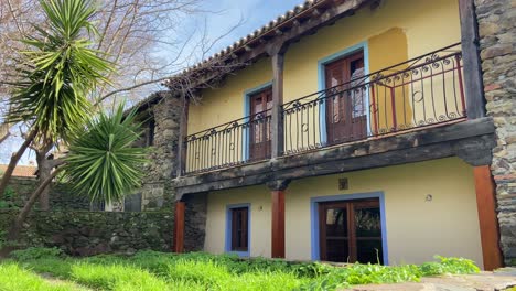 Panning-right-shot-revealing-picturesque-rural-colourful-house-with-little-backyard-garden-in-Extremadura,-Spain