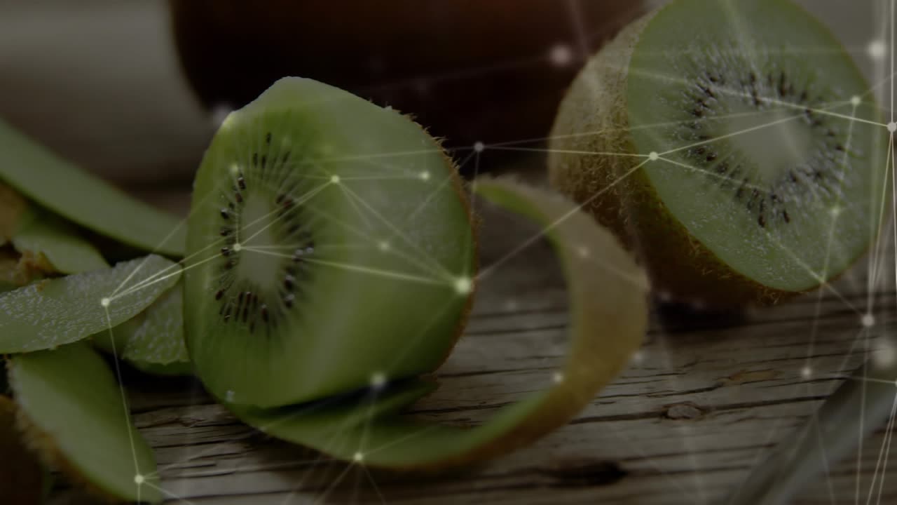 Cámara retrocediendo, un kiwi partido a la mitad girando, la cáscara rizándose, rebanadas formándose, con una superposición brillante para anuncios
