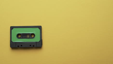 video of retro tape with green label with copy space on yellow background