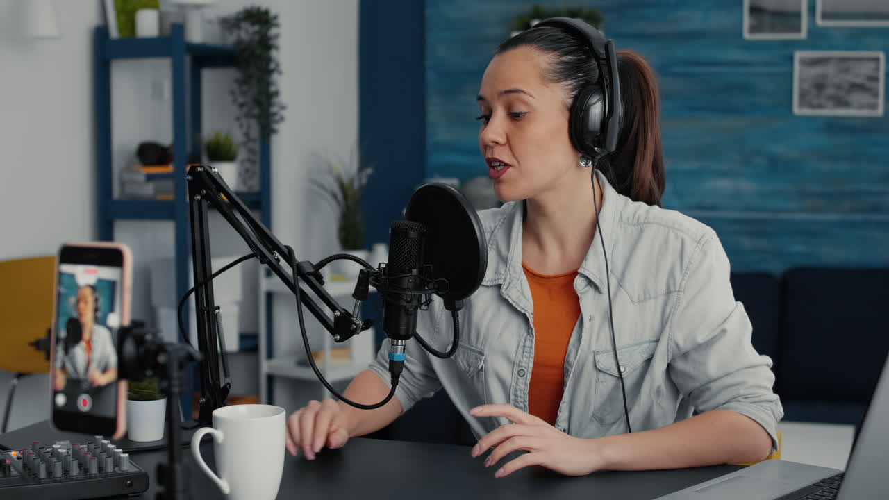 Happy influencer starting to record daily vlog while putting on headphones in home studio