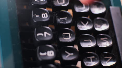 teclado de una máquina de escribir con dedos masculinos blancos escribiendo