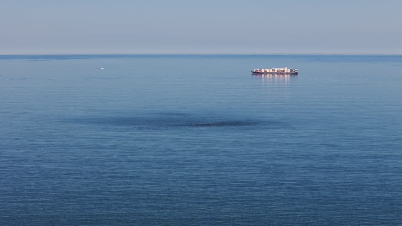 배경 에 지평선 이 있는 조용 한 파란 바다 에서 떠다니는 외로운 전체 컨테이너 선박 의 드론 클립